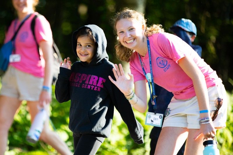 Camper waving with Cabin Counselor