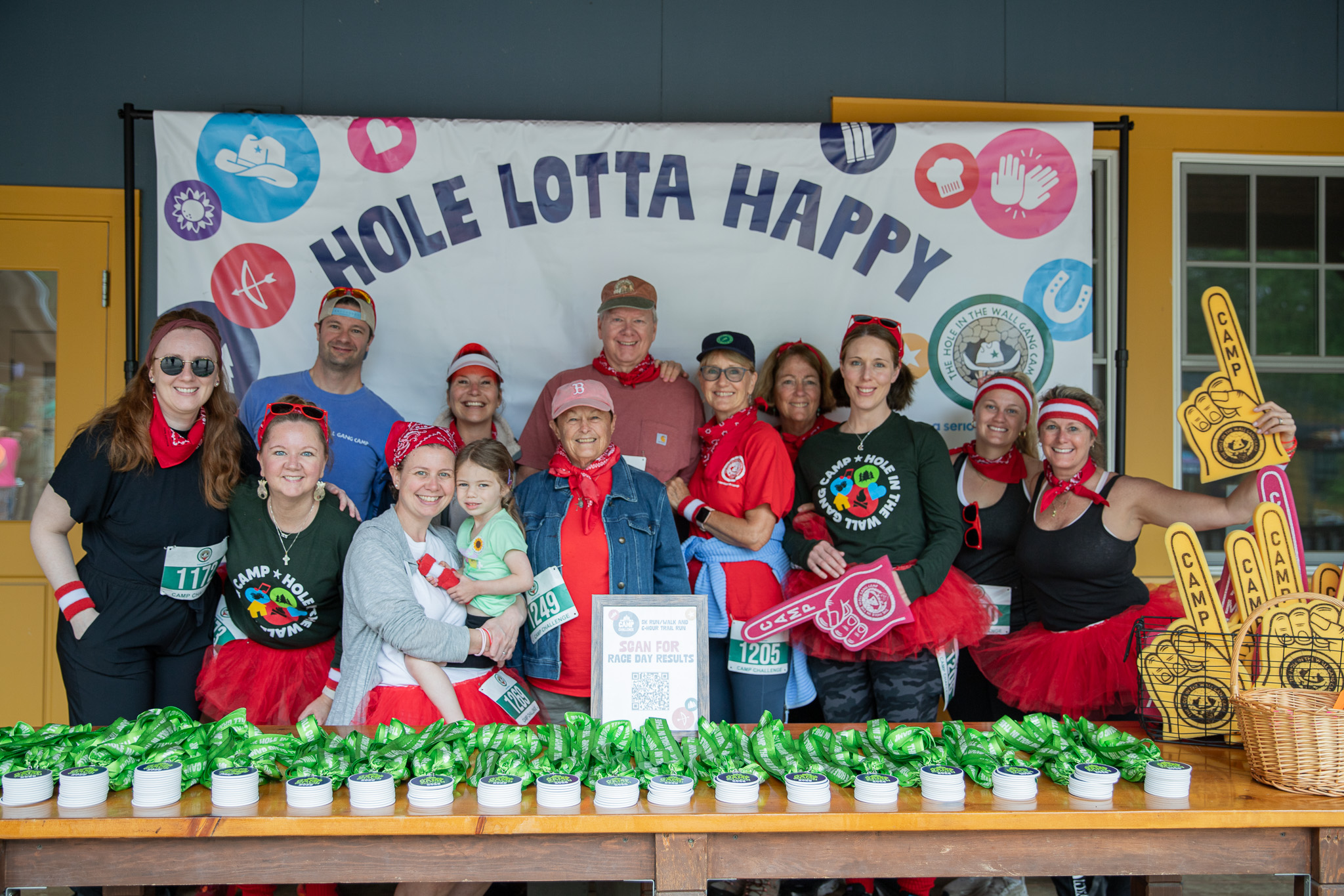 A Cabin Circle group poses behind a table of Challenge medals at the 2025 Camp Challenge