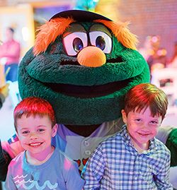 Two boys smile with Wally the Green Monster at the Bash