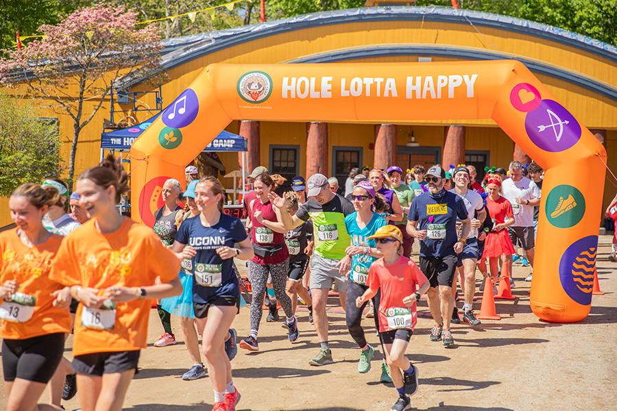 Runners start the 5k under a sunny sky with smiles at the 2026 Camp Challenge