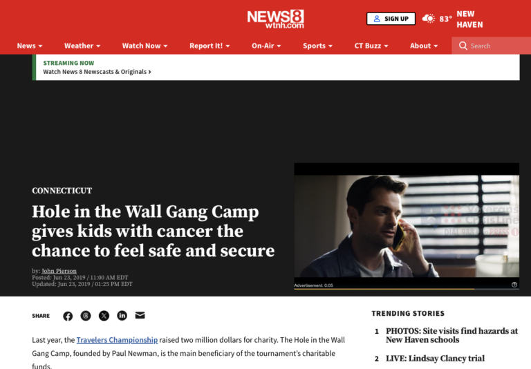 A news website article headline reads: Hole in the Wall Gang Camp gives kids with cancer the chance to feel safe and secure, with an image of a man talking on the phone and a list of trending stories on the right.