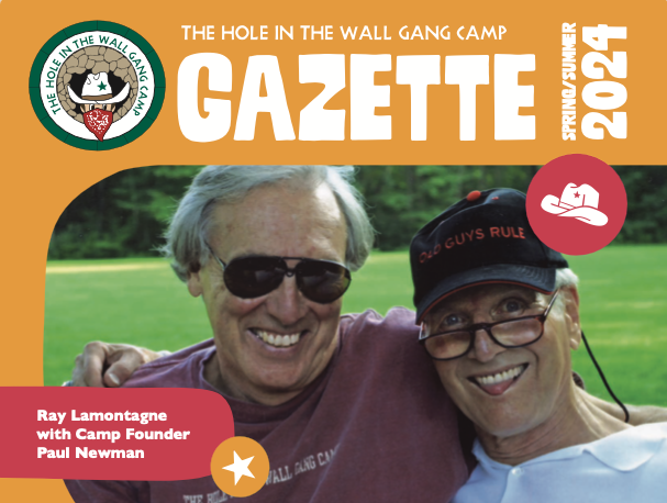 Two smiling men sit together outdoors wearing sunglasses. One wears a brown shirt; the other, a black Old Guys Rule cap. Text reads: Ray Lamontagne with Camp Founder Paul Newman, The Hole in the Wall Gang Camp Gazette, Spring/Summer 2024.