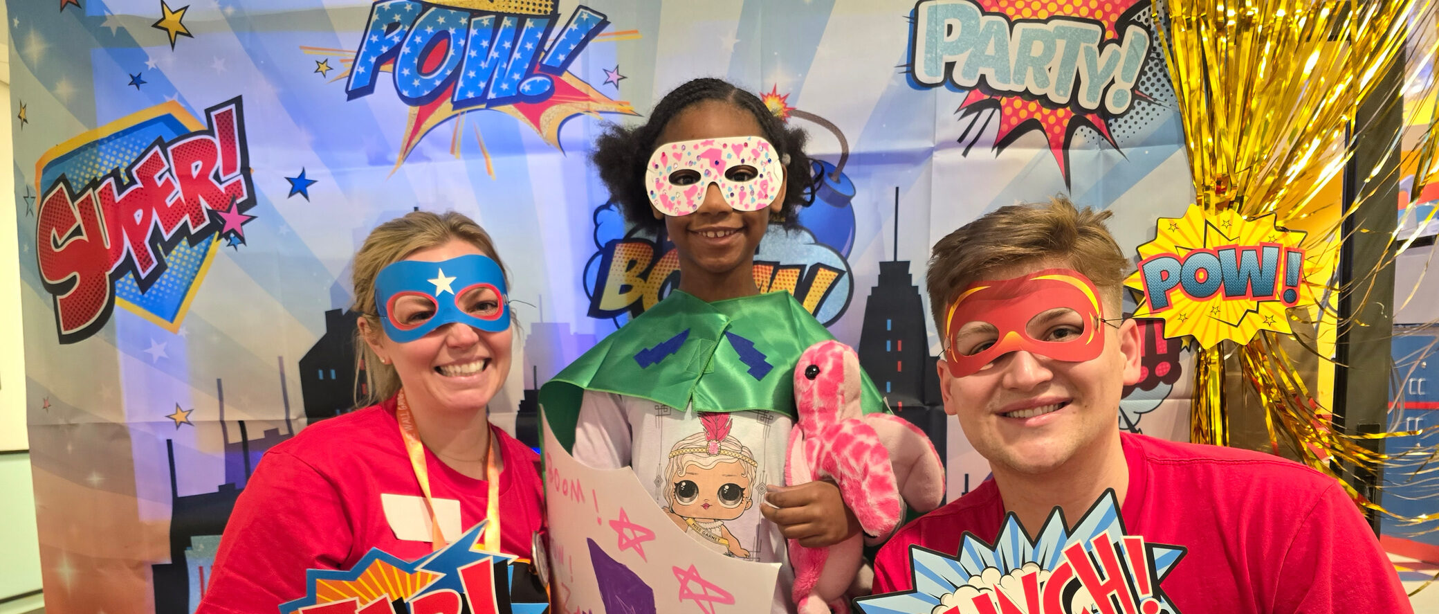 Camp staff pose for a superhero themed photo booth during Superhero Days at Connecticut Children's Medical Center