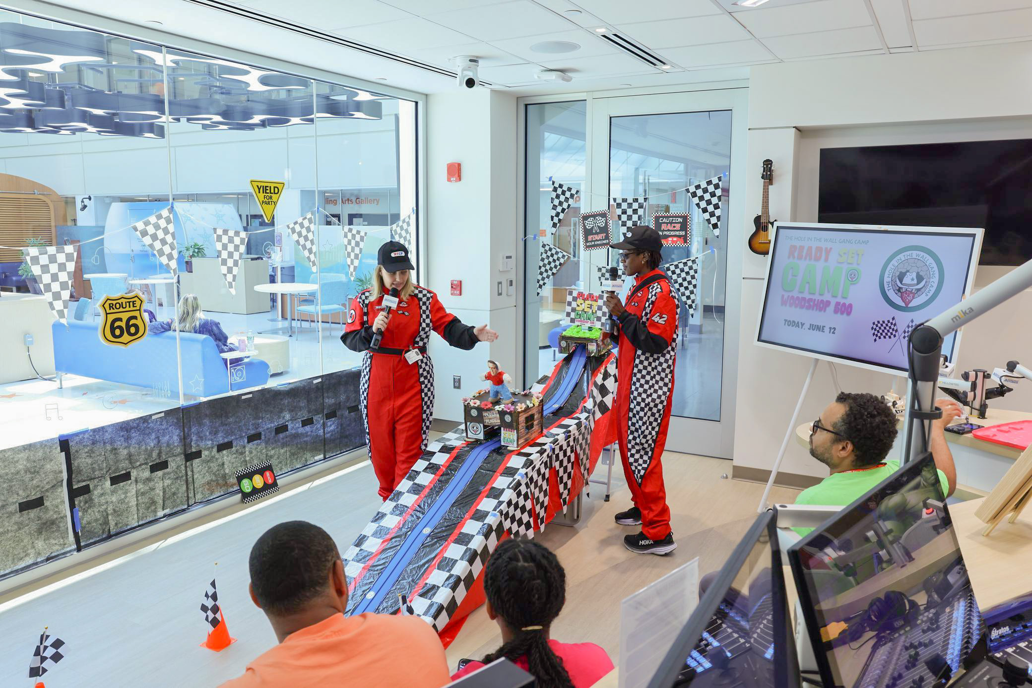 HOP Specialists cheer on cars built by hospital patients during a Woodshop 500 race broadcast across Cohen Children's CCTV