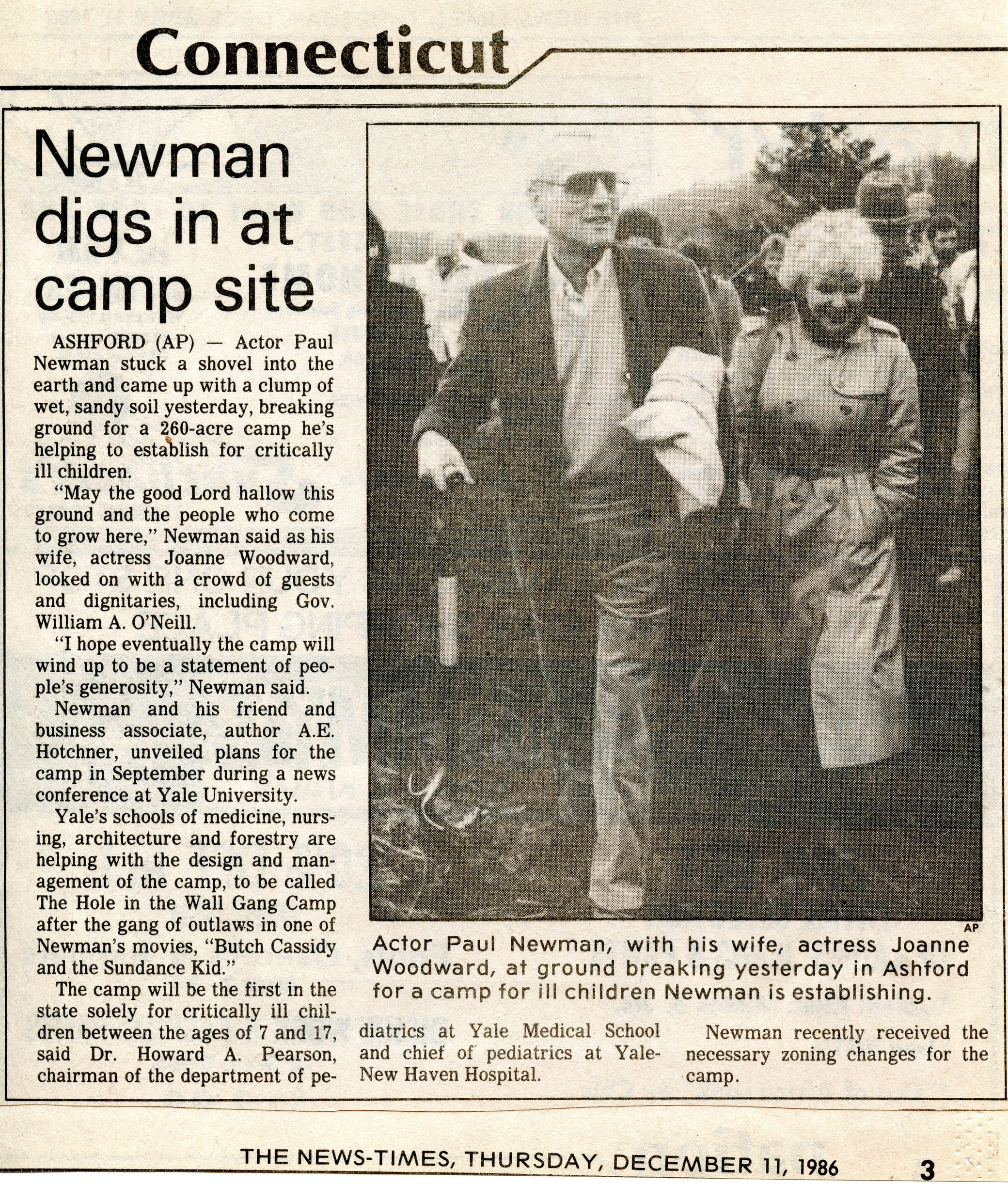 Newspaper clipping with a photo of Paul Newman and Joanne Woodward holding a shovel at a groundbreaking event, with an article about Newman starting a camp for ill children in Ashford, Connecticut.