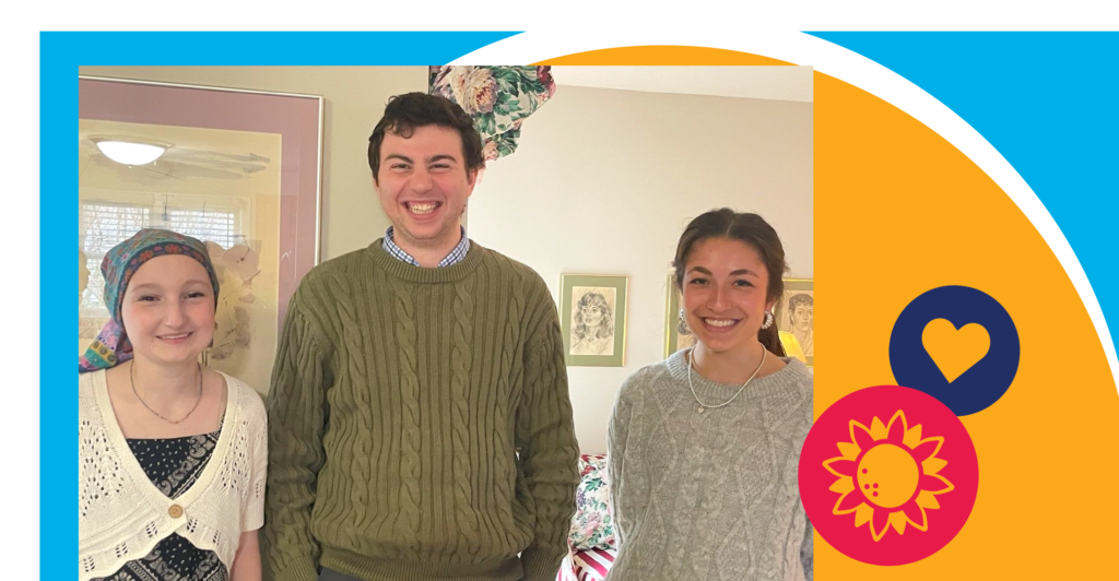 Three young adults stand indoors, smiling at the camera. The background has framed art. The photo is bordered with bright blue and orange colors, and flower and heart icons decorate the bottom right corner.