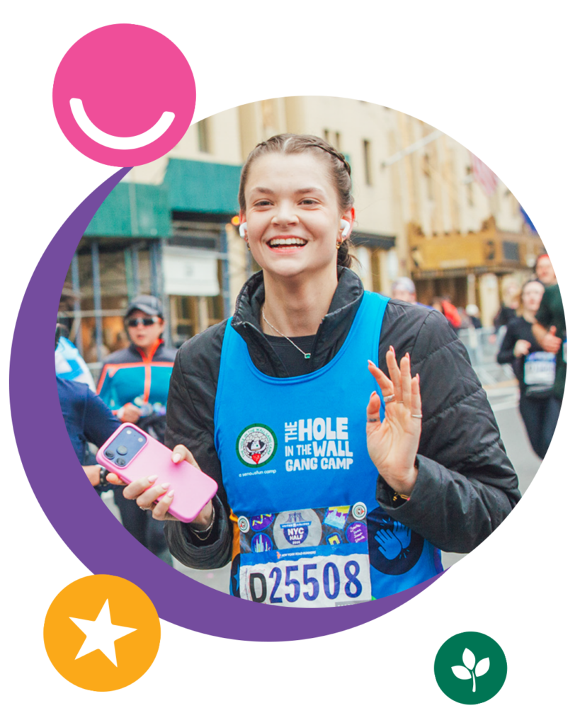 A smiling runner in a blue Hole in the Wall Gang Camp bib waves during a race. She holds a phone and wears earphones. Colorful icons—a smile, star, and leaf—decorate the images border.